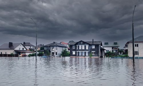 Bad extreme heavy rain storm weather. Flooded streets of the neighborhood. A flooded road junction with a drowned car. Heavy rains from tropical storm caused many flooded areas.